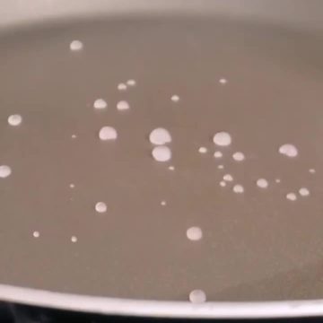 Wassertropfen tanzen auf der heissen Pfanne